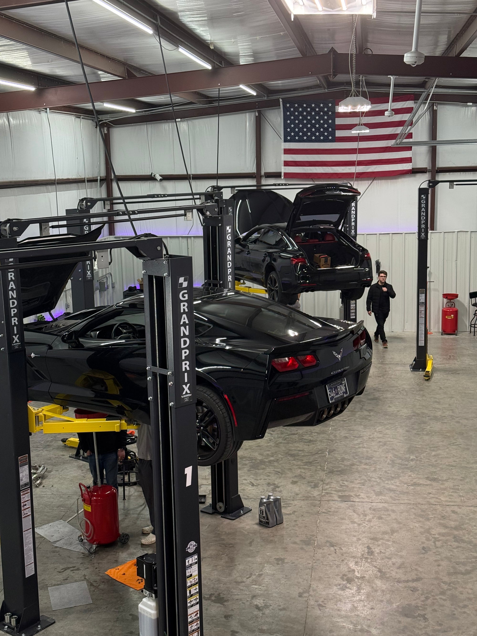 Customer working on a car raised on a lift at LATE Garage